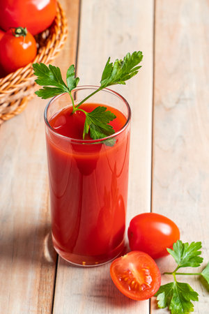 Fresh tomato juice on a wooden rustic background. Organic vegetable drink with parsley.の写真素材