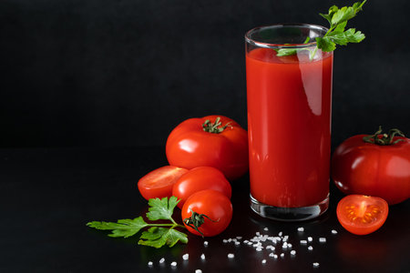 Delicious tomato juice on a black background. Vegetable drink for vegan and healthy eating.の写真素材