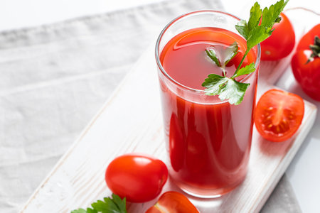 Refreshing tomato juice with parsley on a white background. Vegan vegetable smoothie.の写真素材