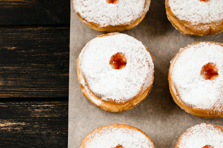 Happy Hanukkah. Traditional dessert Sufganiyot on dark wooden background. Donuts, candles and gifts. Celebrating Jewish religious holiday.の写真素材