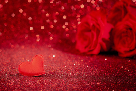Roses and heart on red glittering bokeh background. Valentine's day, place for text.の写真素材