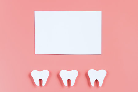 Paper cut tooth mockup and greeting card on pink background. Happy dentist day. Copy space.の写真素材