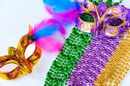Two carnival masks with feathers and multi-colored beads on white background. Mardi Gras or Fat Tuesday symbol. Greeting card for for traditional holiday.の写真素材