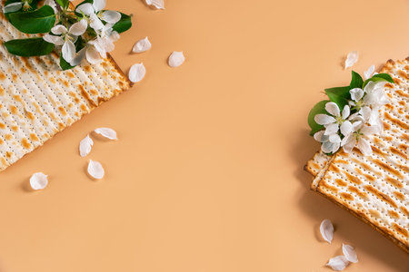 Traditional Jewish holiday Passover. Spring flowers and matzah bread on beige background. Copy space. Festive flatlay.の写真素材