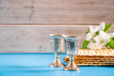 Happy passover. Metal goblet and traditional matzah on blue background. Symbols of Jewish holiday.の写真素材