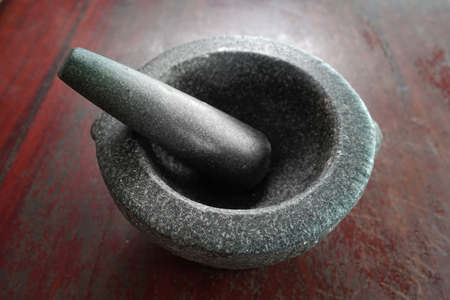 Mortar stone, pestle and spice on wooden table.の写真素材