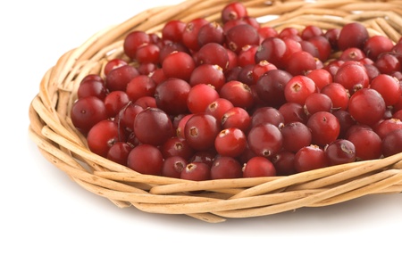 Cranberries in a wicker tray on a white backgroundの写真素材