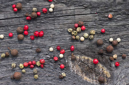 Multicolored peppers peas scattered on the wooden deskの写真素材