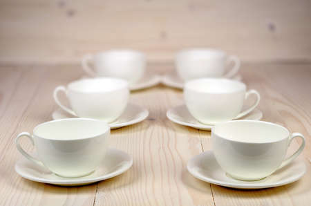 cups and plates on wooden background blurredの写真素材
