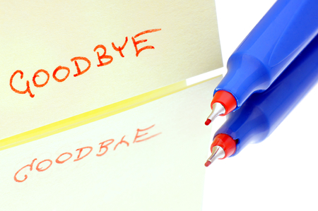 Hand written word  goodbye  on paper laid on the glass with a pencil の写真素材