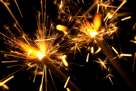 Two sizzling sparklers in the dark の写真素材