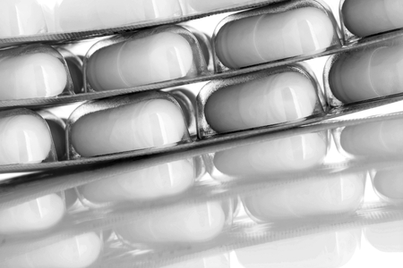Food supplement in gelatin capsules in packaging reflection from the glossy surface.の写真素材
