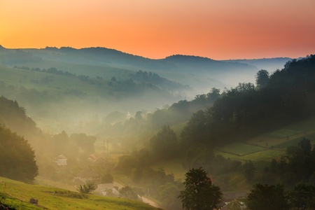 village in the mountains in the early morning fogの写真素材