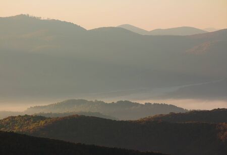 cold morning fog with red hot sunrise in the mountains in the morningの写真素材