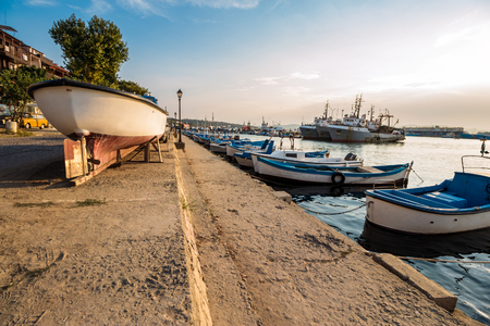 SOZOPOL - AUGUST 16: fishing boats at sunset on August 16, 2015 in Sozopol, Bulgaria. small fishing boats and few big one docked near embankment in port of Bulgarian town Sozopol in evening lightのeditorial素材