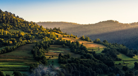Agricultural fields on hills in mountainous rural area at sunriseの写真素材