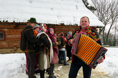 Uzhgorod, Ukraine - January 15, 2017: "Carols in old village" festival in TransCarpathian Regional Museum of Folk Architecture and Life. Man in national suit plays accordionのeditorial素材