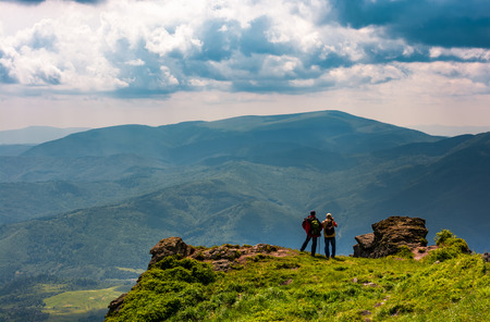 tourists stand on cliff enjoying the view. gorgeous view of magnificent Polonina Runa ridge from the hills of Pikui mountain. Location Ukrainian Carpathiansの写真素材