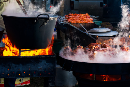 Pork butchers competition. boiling cauldron on fire. meat cooking on steamy plate. blank barbecue in...