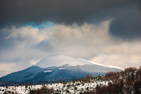 dramatic sky above the distant snowy peak. beautiful winter sceneryの写真素材