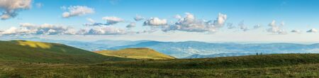beautiful summer landscape in mountains. grassy alpine meadows in evening light. wonderful weather with fluffy cloudsの写真素材