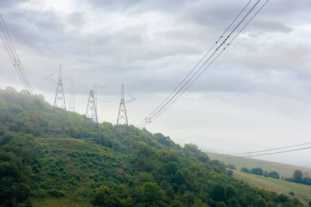 high voltage power lines tower in mountains.  energy delivery background. efficient electricity...