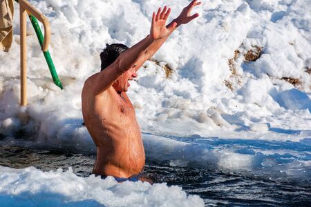 uzhhorod, ukraine - 19 JAN 2017: epiphany bathing on a sunny day. god blessed tradition of true orthodox Christians. dipping in the icy-hole with splashes and funny emotions. he is the winner signのeditorial素材