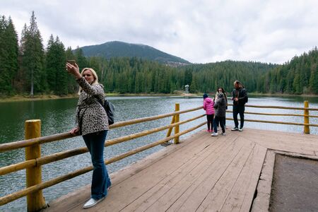 synevir national park, ukraine - MAY 09, 2017: people enjoying the beauty of Carpathian landscape. natural mountain lake attracts thousands of tourist to observe, relax and take selfies for memoriesのeditorial素材
