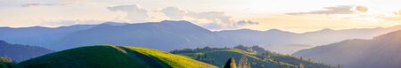 panorama of mountainous countryside in springtime at dusk. path through rolling hills. ridge in the...