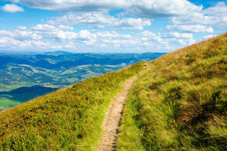travers path through mountain range. grass on the hills and steep slopes. summer landscape on a sunny day.の写真素材