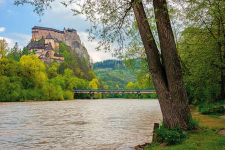 oravsky podzamok, slovakia - MAY 01, 2019: oravsky castle on the hill near the river. popular travel destination. beautiful springtime scenery in dappled lightのeditorial素材