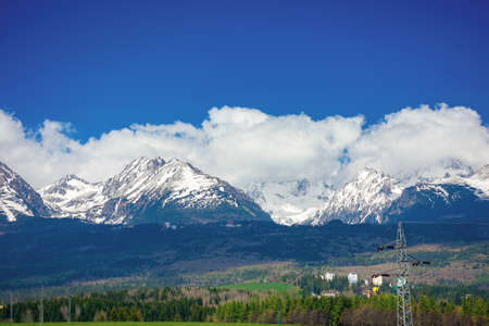 high tatra mountain ridge in springtime. cloud above the snow capped rocky peaks. beautiful sunny...