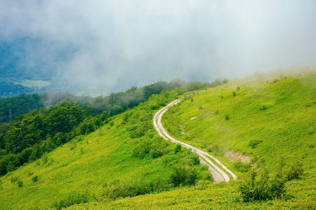 road through mountain hills. beautiful summer landscape in the morning. clouds on the skyの写真素材
