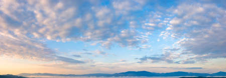 fluffy clouds on the azure sky at sunrise. beautiful nature background. panoramic view in golden...