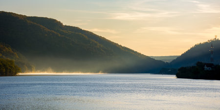 morning landscape of mountain lake at sunrise. beautiful autumnal countryside scenery with fog on the water in the distance. cold somes water reserve of cluj country, romaniaの写真素材