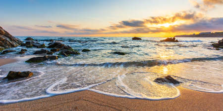 summer vacation at the beach. idyllic seascape at sunrise. calm waves washing the shore with sand...