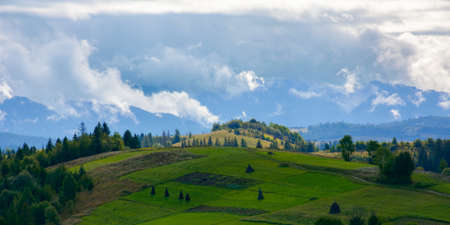 mountainous countryside landscape in september. rural fields and forest on the hills rolling in to...