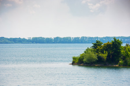 island on strbske pleso water reserve. tranquil nature background. calm summer weatherの写真素材