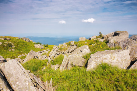 mountainous countryside in summer. boulders and rock formations among the grassy hills. sunny forenoonの写真素材