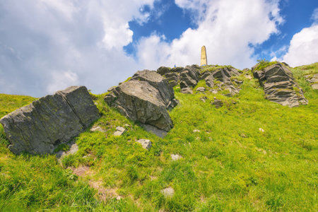 ukrainian carpathians watershed ridge adventures. terrain with stones and rocks of pikui mountan. green slopes beneath a blue sky with fluffy clouds. wonderful summer vacations on a sunny dayの写真素材