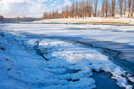 urban landscape with frozen river. winter scenery with trees on the riversideの写真素材