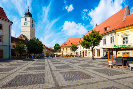 sibiu, romania - 25 jun, 2017: cityscape of piata mica square. beautiful town architecture with church in the distance on a sunny day. popular travel destination of transylavniaのeditorial素材