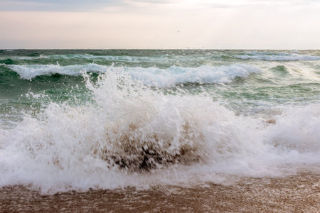 waves crashing the shore. stormy seascape in morning lightの写真素材