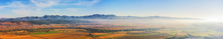 panorama of romania countryside in morning light. autumnal landscape in mountains. grassy field and rolling hills. rural sceneryの写真素材