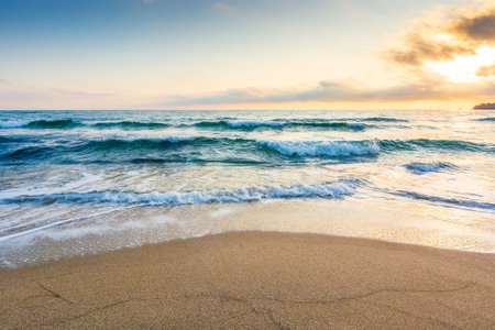 empty beach in the forenoon. wet seashore. beautiful landscape at the sea. waves washing the sand on...