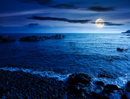 pebble coast at night. beautiful summer vacation season at the sea in full moon lightの写真素材