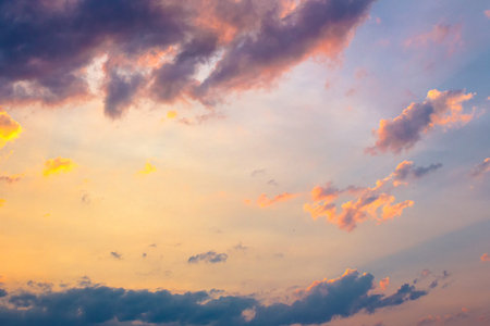 dark cloudscape at sunset. orange-purple clouds on a yellow-blue gradient of sky in evening light....