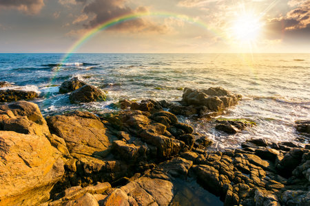 weekend on a rocky beach at the sea under open blue sky at sunset. beautiful coastline in summer. seascape scenery with clouds above horizon in evening light. sunny weatherの写真素材