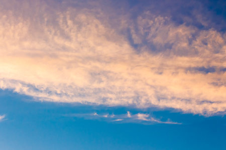 orange cloud on blue sky at sunset. beautiful nature background at dusk for meteorology. cloudscape in yellow light. abstract scene of summer weatherの写真素材