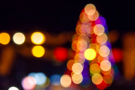 winter holiday colorful bokeh. festive decorated christmas tree lights on city street for beautiful...